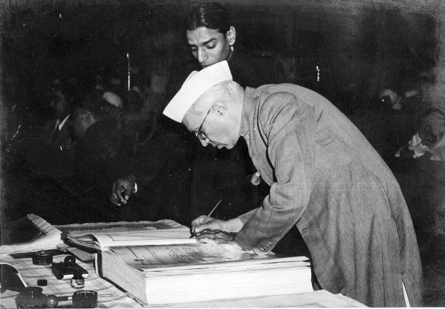 Jawaharlal Nehru signing the Indian Constitution